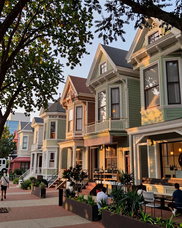 Heights Houston tree-lined avenue with restored craftsman homes and boutique wine bars